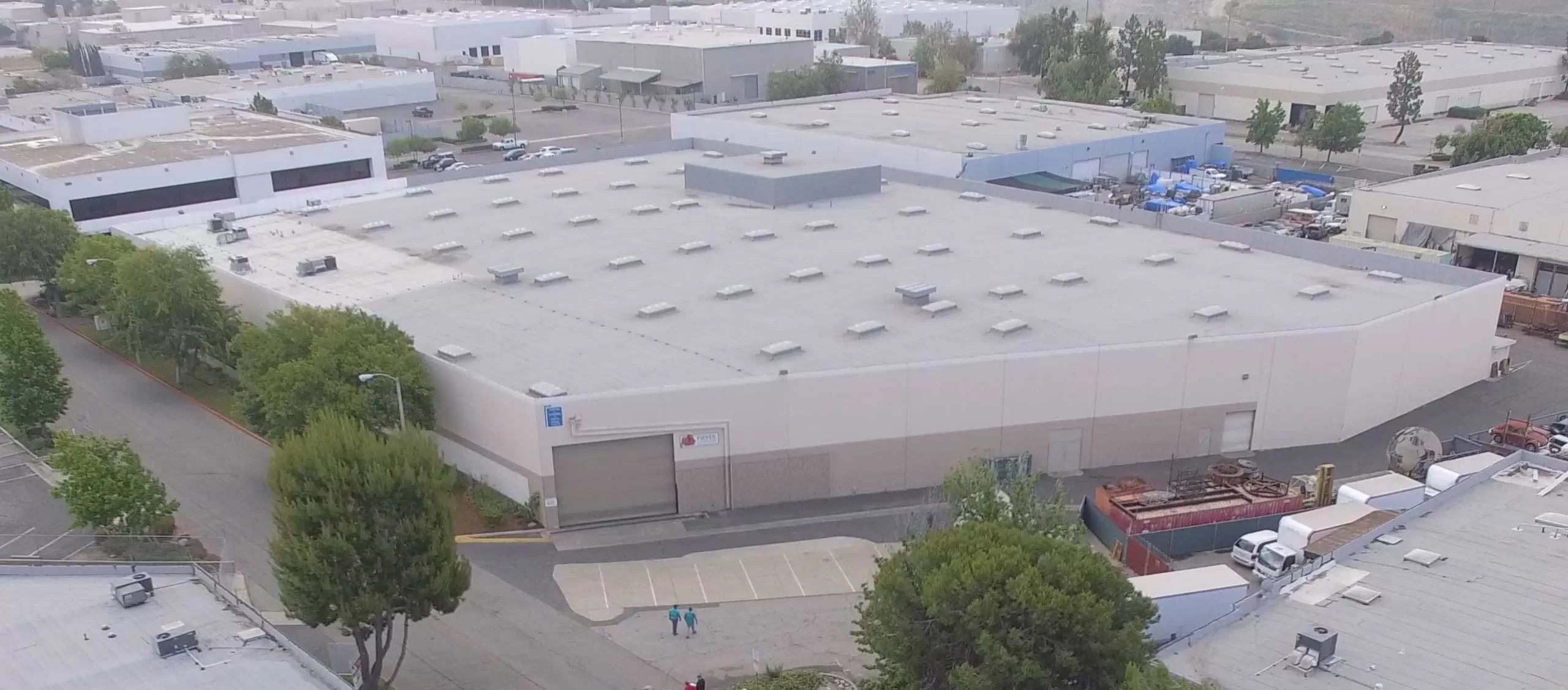 Aerial view of a large industrial warehouse with multiple air vents on the roof
